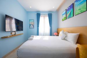 een slaapkamer met een groot bed met blauwe muren bij Lotus Home Cafe in Phu Quoc