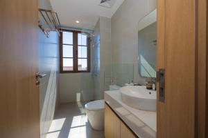 een badkamer met een wastafel, een toilet en een spiegel bij Lotus Home Cafe in Phu Quoc