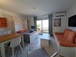 ein Wohnzimmer mit einem Bett und einer Couch in der Unterkunft STUDIO Terrasse Plage CLIM WIFI Park in Palavas-les-Flots