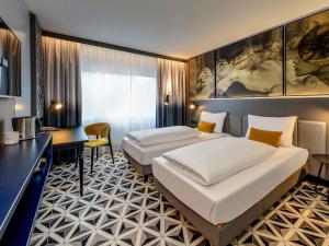 Postel nebo postele na pokoji v ubytování Mercure Hotel Freiburg am Münster