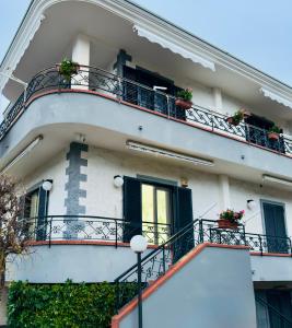 een wit gebouw met balkons en bloemen erop bij Civico27 in SantʼAntonio Abate