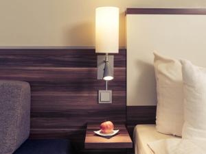 a bedroom with a bed and a table with a fruit on a plate at Mercure Hotel Saarbrücken Süd in Saarbrücken +79 photos