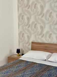 a bedroom with a bed and a wall with a pattern at Civico27 in SantʼAntonio Abate