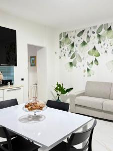 sala de estar blanca con mesa y sofá en Civico27, en SantʼAntonio Abate