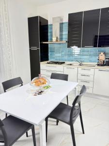 Una cocina blanca con una mesa y sillas blancas. en Civico27, en SantʼAntonio Abate 11 fotos más