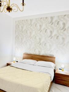 a bedroom with a large bed with a wall at Civico27 in SantʼAntonio Abate