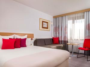 Una habitación de hotel con una cama grande y un sofá. en Novotel Warszawa Airport, en Varsovia