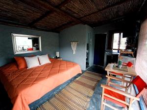 a bedroom with a large bed and a table at Mama Anzas house in a magical mountain in Villabol