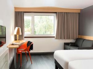 a hotel room with a bed and a desk and a window at ibis 3 Lacs Neuchâtel in Thielle-Wavre
