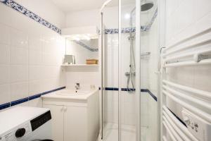 a white bathroom with a shower and a sink at Les Oyats - Parking - Balcon - Plage in Le Touquet-Paris-Plage