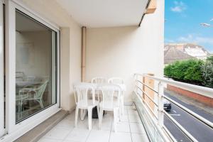 a balcony with white chairs and a table at Les Oyats - Parking - Balcon - Plage in Le Touquet-Paris-Plage