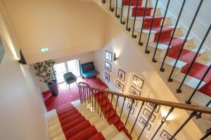 an overhead view of a staircase in a house with red carpet at La Léontine in Abbeville