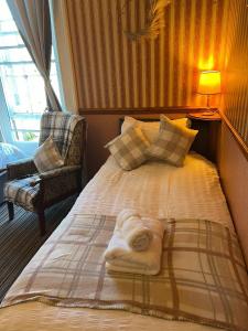 a bed with a towel on it in a room at Edinburgh Travel Guest House in Edinburgh