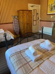 a bedroom with two towels on a bed at Edinburgh Travel Guest House in Edinburgh