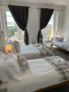 a bedroom with two beds and a large window at Edinburgh Travel Guest House in Edinburgh