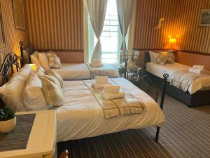 a hotel room with two beds with towels on them at Edinburgh Travel Guest House in Edinburgh +23 photos