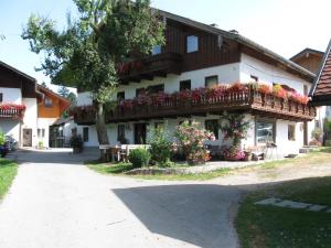 a building with a balcony with flowers on it at Ferienwohnung Grubinger in Unterach am Attersee