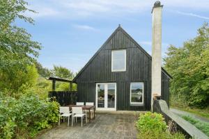 EgPanorama, Nature & Peace In Idyllic Mols的一间黑色谷仓式小屋，里面摆放着桌椅。