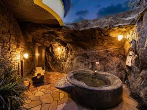 een stenen badkamer met een bad in een grot bij Hotel LaLa (Adult Only) in Sakai