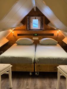 two beds in a room with a attic at Villa Pats in Gilze