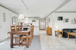 a kitchen and living room with a wooden table and chairs at Well-Designed House In Scenic Surroundings in Martofte +6 photos