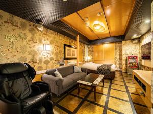 een woonkamer met een bank en een bed bij Hotel LaLa (Adult Only) in Sakai