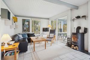 a living room with a couch and a wood stove at Well-Designed House In Scenic Surroundings in Martofte
