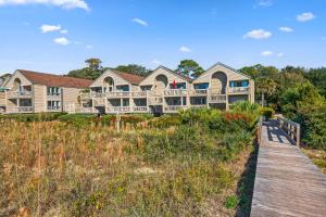 a large house on the beach with a wooden boardwalk at PW1310: 1310 Pelican Watch in Seabrook Island