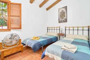 a bedroom with two beds and a window at Cortijo A Navas in Frigiliana +25 photos