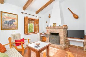 a living room with a fireplace and a tv at Cortijo A Navas in Frigiliana