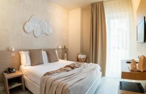 a bedroom with a bed with a blanket on it at Hotel Renania in Bibione