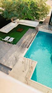 una vista aérea de una piscina con sillas y una mesa en Hummingbird Rak, en Ras al Khaimah
