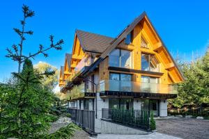 a house with a gambrel roof at Aparthotel Białka SKI, Odkryj-Bialke in Białka Tatrzańska
