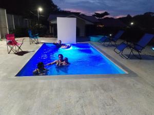 un groupe de personnes dans une piscine la nuit dans l'établissement Casa Chika, Playa Grande Guanacaste, Casa Completa, à Cuajiniquil
