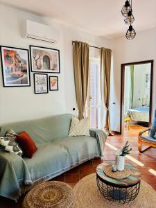a living room with a green couch and a table at Brezza Calabra Sea View Apartments in Scalea