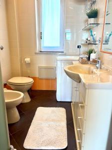 a bathroom with two sinks and a toilet and a window at Brezza Calabra Sea View Apartments in Scalea +28 photos