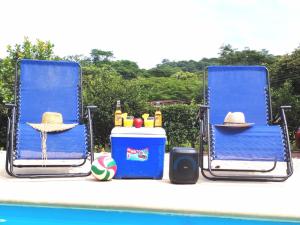 - deux chaises bleues installées à côté de la piscine dans l'établissement Casa Chika, Playa Grande Guanacaste, Casa Completa, à Cuajiniquil