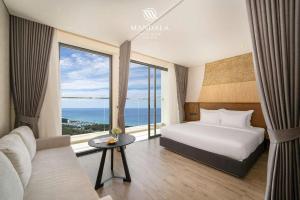 ein Hotelzimmer mit einem Bett und einem großen Fenster in der Unterkunft Khách Sạn Apec Mandala Whyndham Tuy Hoa -Phú Yên in Phước Hậu (1) + 33 Fotos