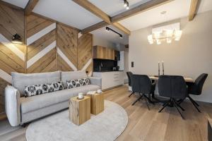 a living room with a couch and a table at Aparthotel Białka SKI, Odkryj-Bialke in Białka Tatrzańska