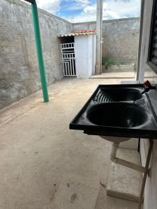 a black sink in a room with a building at Casa LF com suíte e garagem coberta in Mineiros