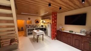a kitchen with a table and a tv on the wall at Casa 678 in Belém