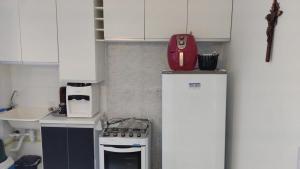 una cucina con un frigorifero e uno zaino rosso sopra di Apartamento em Maceió a Maceió