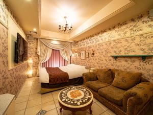 een hotelkamer met een bed en een bank bij Hotel LaLa (Adult Only) in Sakai