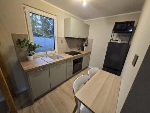 a kitchen with a sink and a table and a window at Domek pod Skrzycznym in Kalna
