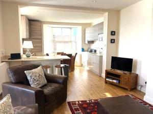 a living room with a couch and a kitchen at Cliff Top Apartment in Filey