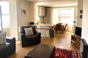 a living room with a couch and a kitchen at Cliff Top Apartment in Filey
