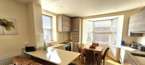 a kitchen with a table and a dining room at Cliff Top Apartment in Filey