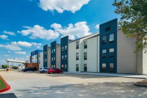 ein Bürogebäude mit auf einem Parkplatz abgestellten Autos in der Unterkunft Holiday Inn Express & Suites Joplin Southeast by IHG in Joplin