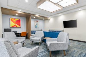 ein Wartezimmer mit Stühlen und einem TV in der Unterkunft Holiday Inn Express & Suites Joplin Southeast by IHG in Joplin