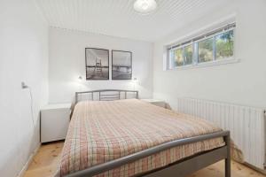 een slaapkamer met een bed en twee ramen bij Family-Friendly Beachside Holiday Home in Arnager